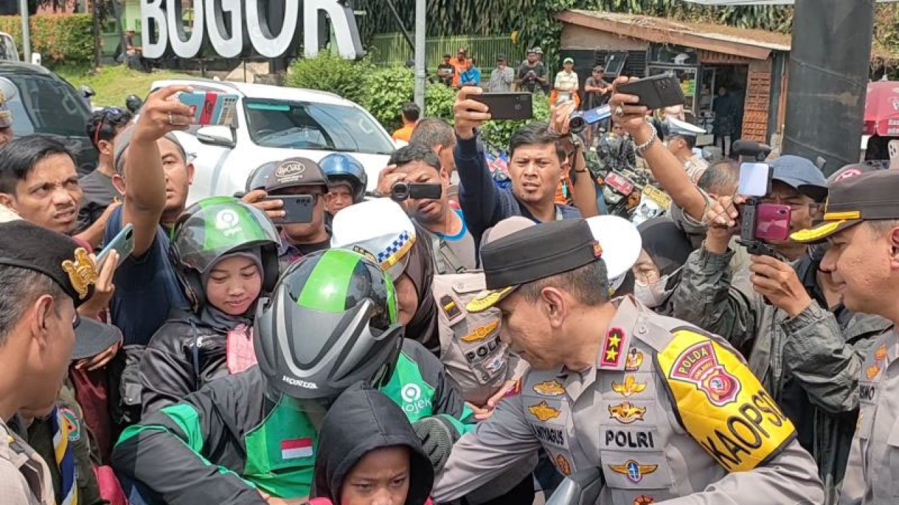 Kapolda Jawa Barat Irjen Pol. Akhmad Wiyagus saat memakaikan rompi pengaman pada anak-anak dari Satlantas Polresta Bogor Kota di Pos Pelayanan Terpadu Baranangsiang, Rabu (26/4/2023). (ANTARA/Linna Susanti)