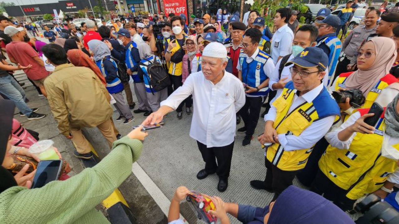 Menteri Pekerjaan Umum dan Perumahan Rakyat (PUPR) Basuki Hadimuljono berinteraksi dengan pemudik di tempat istirahat KM 379A Tol Semarang-Batang di Kabupaten Batang, Jawa Tengah, Selasa. (ANTARA/ I.C.Senjaya)