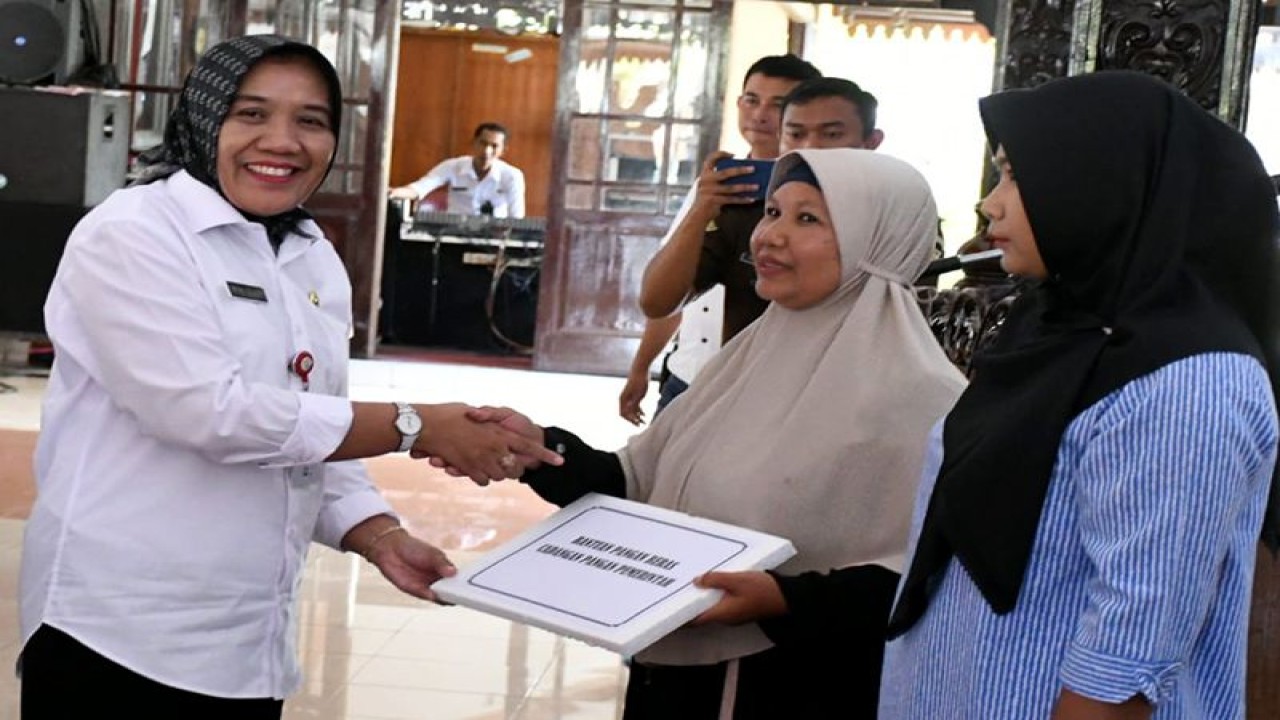 Sekretaris Daerah Kabupaten Purbalingga Herni Sulastri (kiri) secara simbolis menyerahkan beras bantuan dari pemerintah pusat kepada perwakilan keluarga penerima manfaat di Pendopo Dipokusumo, Kabupaten Purbalingga, Rabu (12/4/2023). (ANTARA/HO-Humpro Purbalingga)