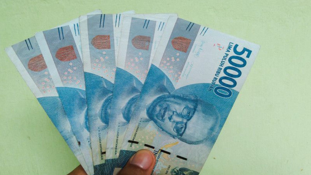 Ilustrasi - Warga menunjukkan uang pecahan Rp50.000 di Denpasar, Senin (10/4/2023) ANTARA/Dewa Ketut Sudiarta Wiguna
