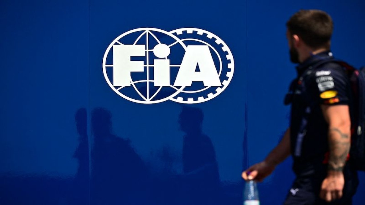 Seorang anggota tim Red Bull berjalan melintasi papan yang bersematkan logo federasi otomotif internasional (FIA) di sela-sela sesi latihan bebas ketiga Formula 1 Grand Prix Arab Saudi di Sirkuti Jeddah Corniche, Jeddah, Arab Saudi, Sabtu (26/3/2022). (ANTARA/AFP/Andrej Isakovic)