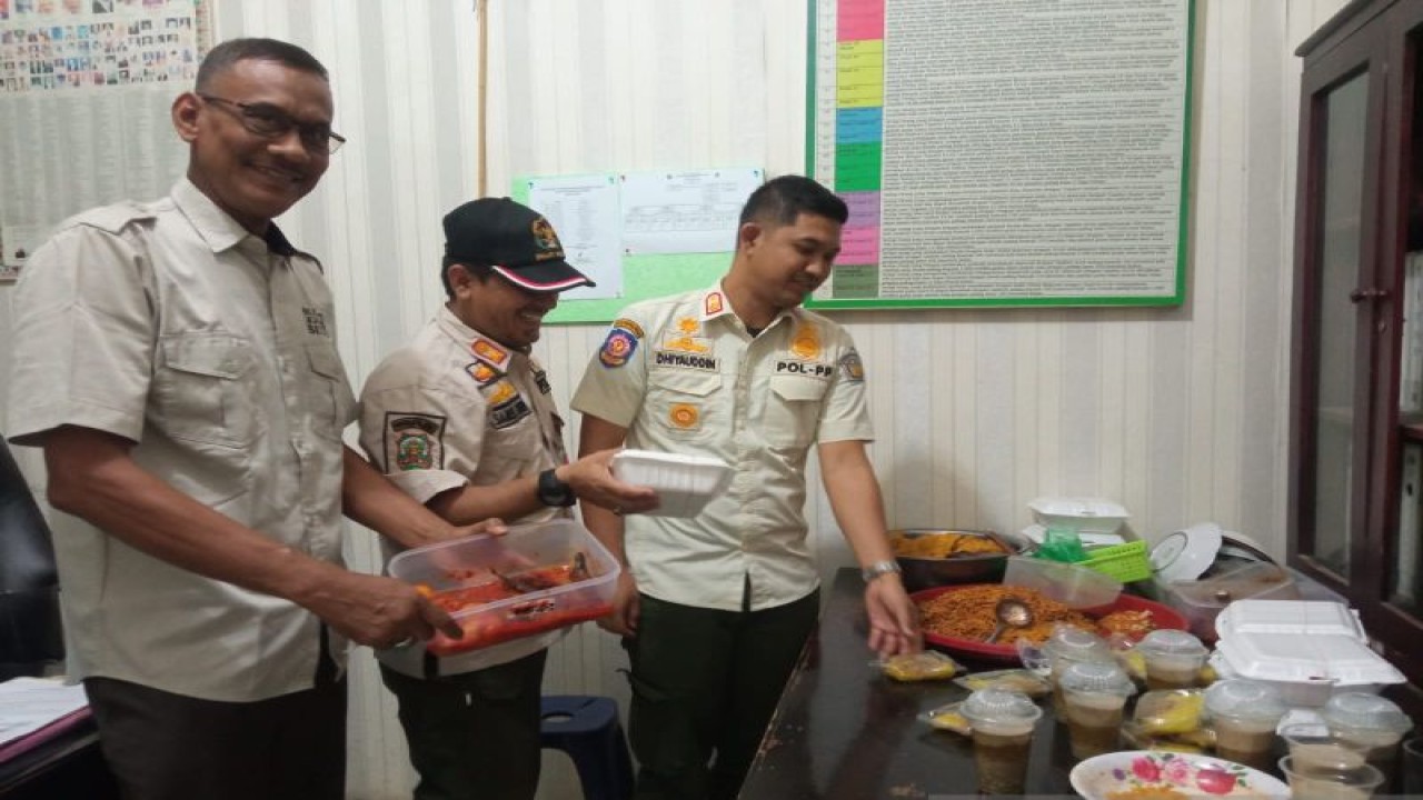Petugas Satpol PP dan WH memperlihatkan makanan yang disita usai melakukan penggerebekan di Lhokseumawe, Aceh, Kamis (6/4/2023). ANTARA/Dedy Syahputra