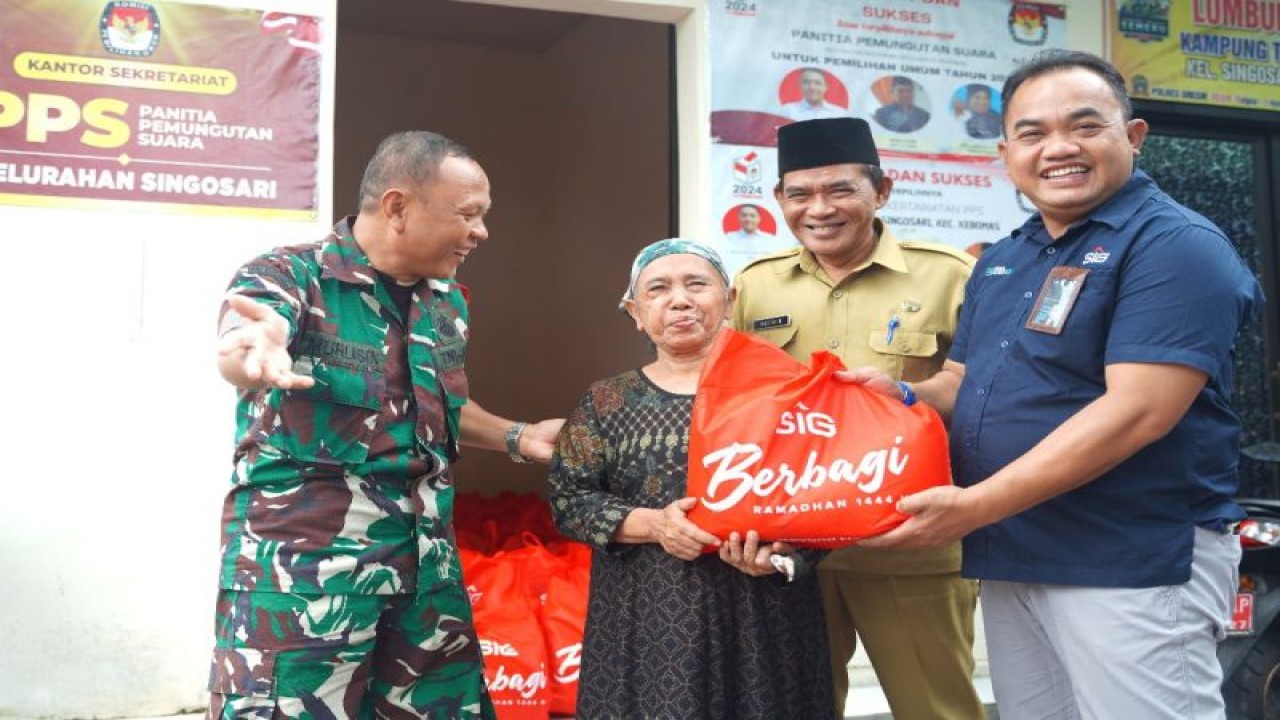 General Manager of CSR SIG, Edy Saraya (paling kanan) didampingi Kepala Kelurahan Singosari, Nastain (kedua kanan), menyerahkan bantuan paket sembako kepada Siti Aminah, warga Kelurahan Singosari, di Pendopo Kelurahan Singosari, Gresik, Jawa Timur, Senin (3/4). (SIG)