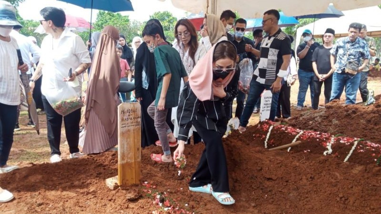Istri Iqbal Pakula, Andiez La'Nuite, menaburkan bunga di makam suaminya pada Selasa (25/4/2023) di TPU Menteng Pulo, Jakarta Selatan. (ANTARA/Farhan Arda Nugraha)
