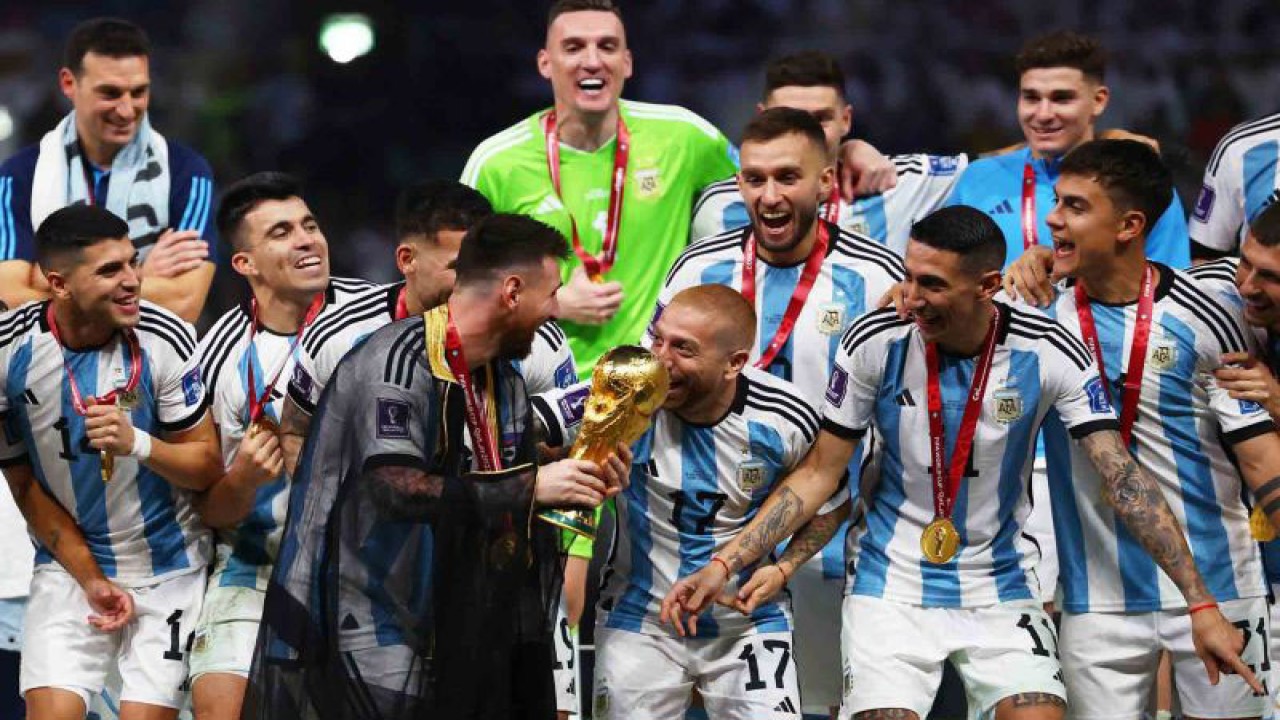 Kapten timnas Argentina Lionel Messi (tengah) disaksikan rekan-rekan setimnya membawa trofi juara FIFA Piala Dunia Qatar 2022 di Stadion Lusail, Lusail, Qatar, Minggu (18/12/2022). Setelah menunggu selama 36 tahun, Argentina akhirnya menjadi kampiun Piala Dunia Qatar 2022 usai mengalahkan Prancis melalui adu penalti 4-2 (3-3). ANTARA FOTO/REUTERS/Kai Pfaffenbach/wsj.