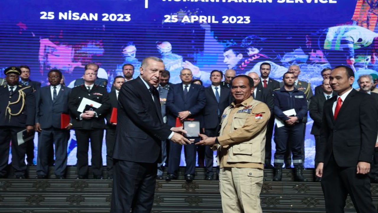 Presiden Turki Recep Tayyip Erdogan (kiri) menyerahkan medali penghargaan kepada pemerintah RI yang diwakili oleh Staf Khusus BNPB Brigjen Lukmansyah (kanan) atas misi penyelamatan Indonesia pasca gempa Turki. (ANTARA/HO-KBRI Ankara)