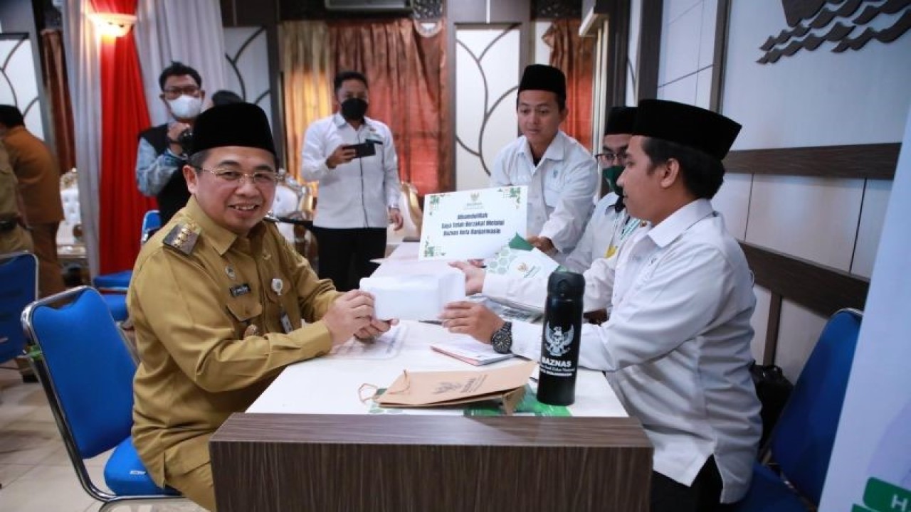 Walikota Banjarmasin H Ibnu Sina (kiri) saat menyerahkan bantuan hibah melalui Badan Amil Zakat Nasional (Baznas) Kota Banjarmasin pada layanan pembayaran Zakat di Aula Kayuh Baimbai Kota Banjarmasin, Kalimantan Selatan, Senin (10/4/2023). (ANTARA/HO-Pemkot Banjarmasin)