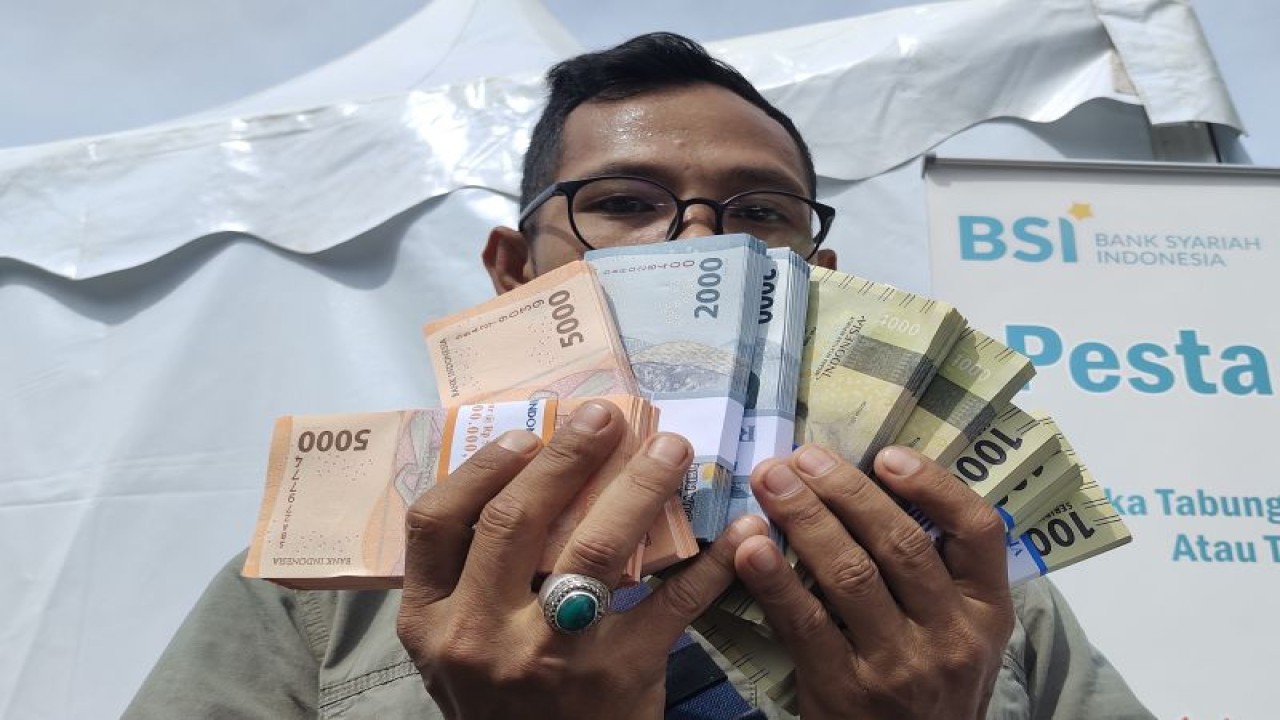 Warga tengah menunjukkan uang pecahan yang telah ditukar menjelang Lebaran 2023. Bandarlampung, Kamis (13/4/2023). ANTARA/Ruth Intan Sozometa Kanafi.