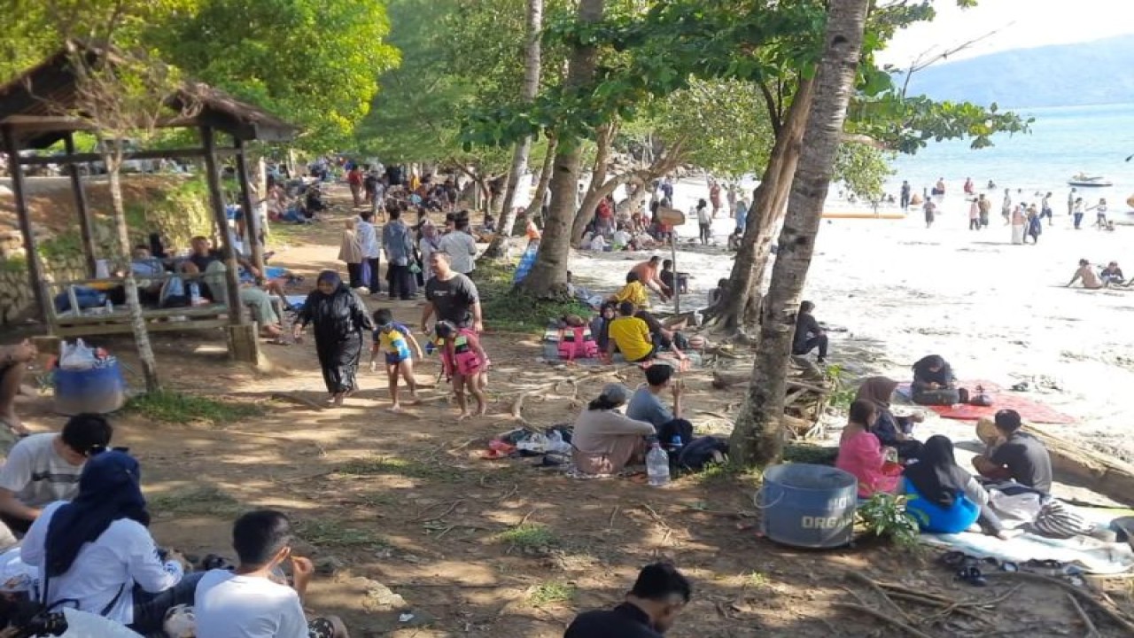 Wisatawan asyik menikmati suasana pesisir di Pantai Pasir Putih Karanggongso, Trenggalek, Kamis (27/4/2023). (ANTARA/HO - Dinas Pariwisata Trenggalek)