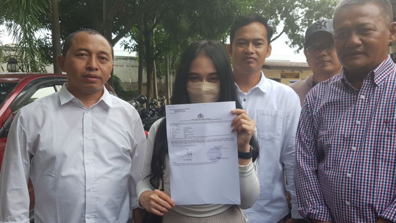 Korban kasus dugaan pelecehan seksual karyawati perusahaan AD (24) menunjukkan bukti laporan di Mapolres Metro Bekasi pada Sabtu (6/5/2023). (ANTARA/Pradita Kurniawan Syah).