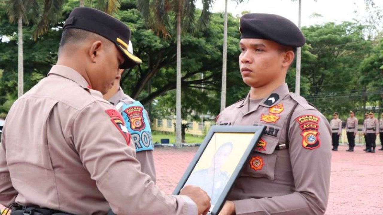 Kapolres Aceh Besar AKBP Carlie saat melakukan PTDH dengan pencoretan foto Brigpol FP dan Brigpol RS karena tidak hadir saat upacara pemecatan dengan tidak hormat (PTDH), di Aceh Besar, Senin (8/5/2023). (ANTARA/HO/Humas Polres Aceh Besar)