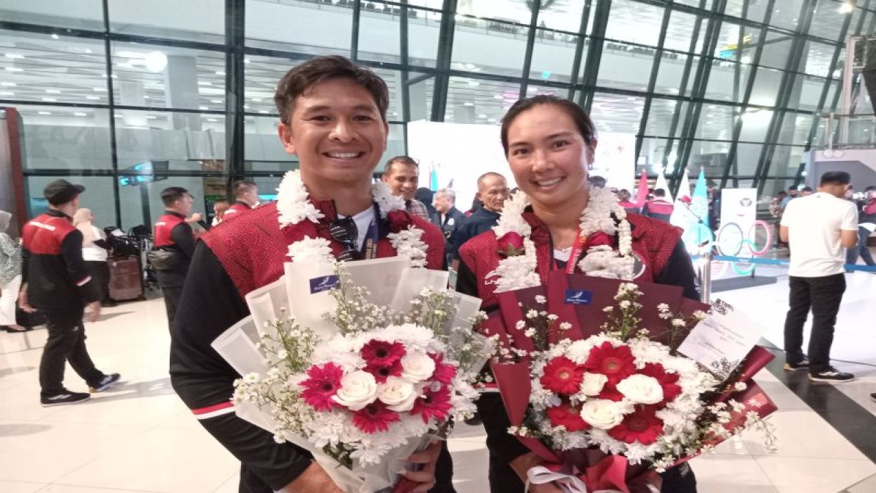 Pasangan ganda campuran tenis Indonesia Christopher Rungkat dan Aldila Sutjiadi berpose setelah upacara penyambutan atlet SEA Games di Bandara Soekarno-Hatta, Tangerang, Senin (15/5/2023). (ANTARA/RAUF ADIPATI)