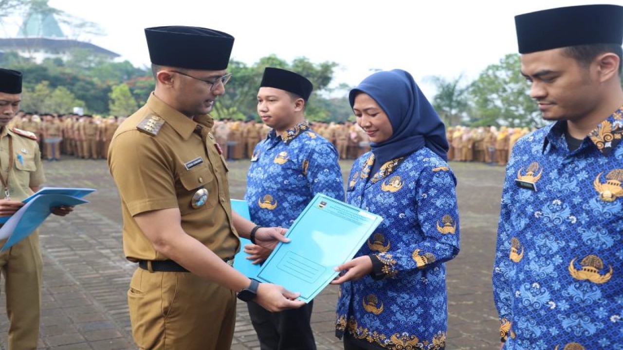 Bupati Bandung Barat Hengki Kurniawan menyerahkan secara simbolis Surat Keputusan (SK) pengangkatan CPNS dan PPPK di Lapang Plasa Mekarsari, Ngamprah, Bandung Barat, Jawa Barat, Senin (8/5/2023). (ANTARA/Pemkab Bandung Barat)