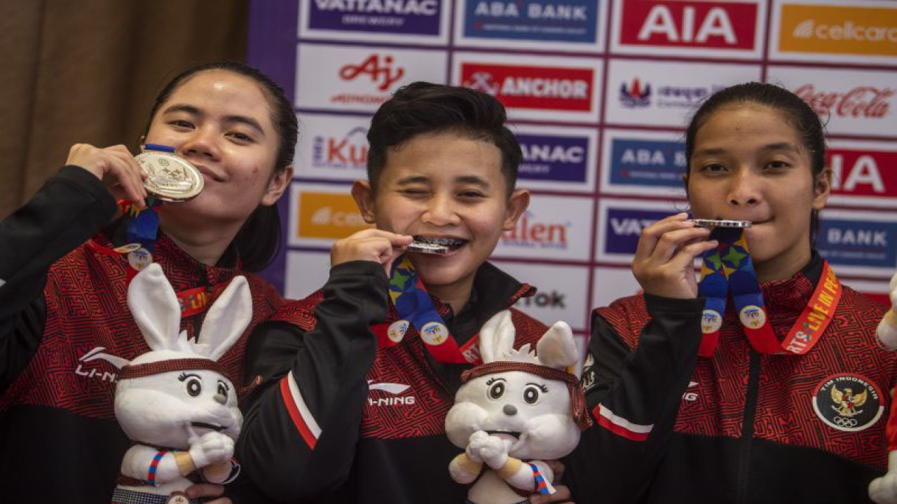 Atlet karate Indonesia Dian Monika Nababan (kanan), Anugerah Nurul Lucky (kiri), Emilia Sri Hanandyta (kedua kanan) mengigit medali usai upacara pengalungan medali nomor kata individual putri dan nomor kata beregu putri saat SEA Games 2023 di Chroy Changvar International Convention & Exhibition Center, Phnom Penh, Kamboja, Sabtu (6/5/2023). Anugerah Nurul Lucky tim berhasil meraih medali perak untuk nomor kata beregu putri. ANTARA FOTO/M Agung Rajasa/hp.
