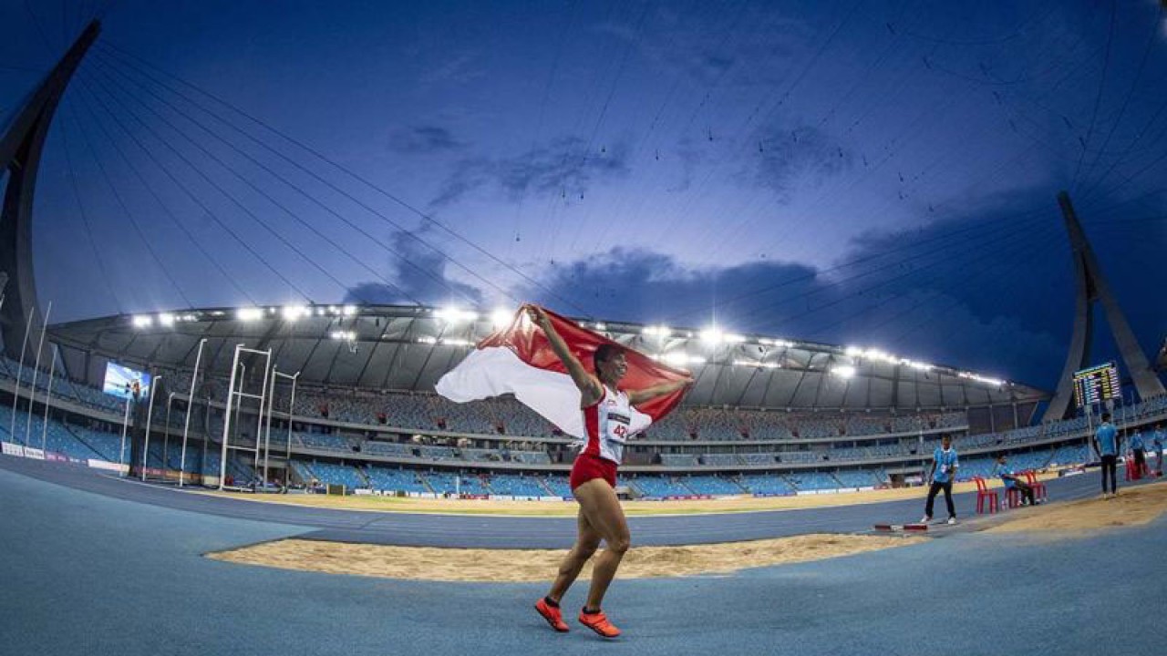 Atlet Indonesia Maria Natalia Londa mengibarkan bendera merah putih usai memastikan meraih medali emas pada nomor lompat jauh putri SEA Games 2023 di Stadion Morodok Techo National Stadium, Kamboja, Rabu (10/5/2023). Maria Natalia Londa berhasil merebut medali emas usai melakukan lompatan terjauh 6,28 meter pada percobaan kelima diikuti dua atlet Vietnam Thi Thu Thoa Bui di peringkat kedua dengan 6,13 meter dan Thi Loan Bui yang meraih perunggu dengan 6,02 meter. ANTARA FOTO/Muhammad Adimaja/nym.