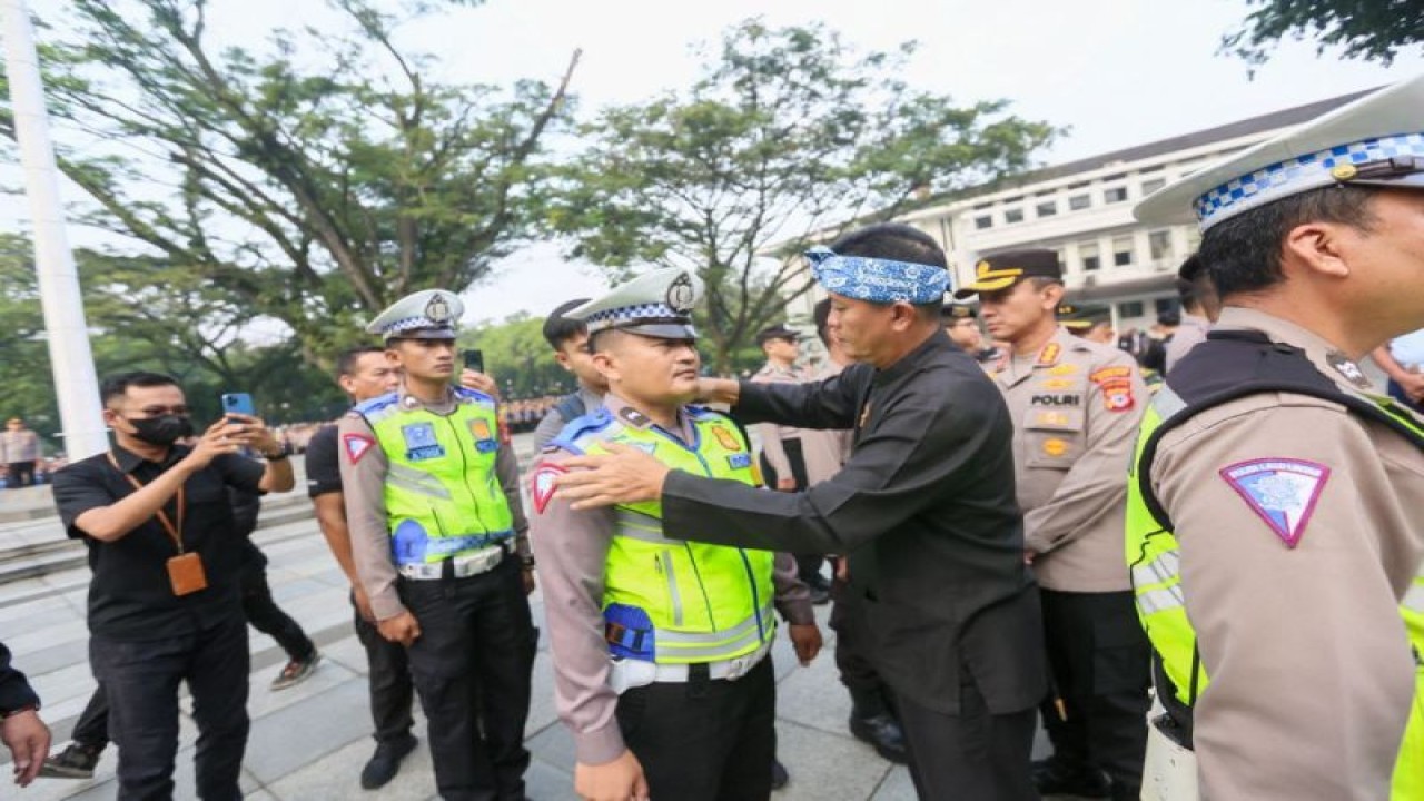 Pelaksana Harian (Plh) Wali Kota Bandung Ema Sumarna didampingi Kapolrestabes Bandung Kombes Pol Budi Sartono menyematkan bange pada perwakilan petugas Polisi RW dalam peluncuran program Polisi RW Kota Bandung di Balai Kota Bandung, Kamis (11/5/2023). (ANTARA/Istimewa)