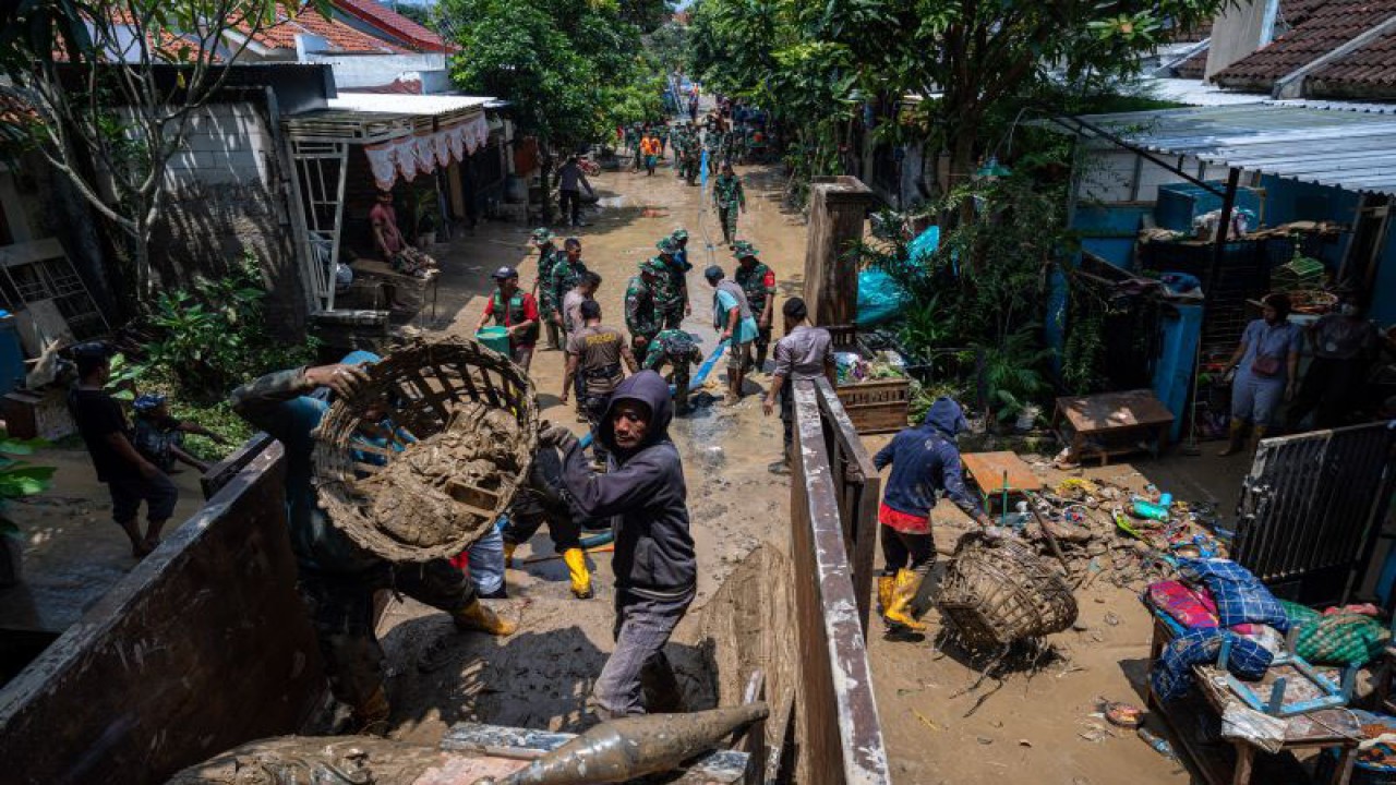 Sejumlah personel TNI-Polri, BPBD Kota Semarang serta relawan membersihkan sisa-sisa banjir pascabanjir bandang yang menerjang Perumahan Dinar Indah, Kelurahan, Meteseh, Kecamatan Tembalang, Semarang, Jawa Tengah, Sabtu (7/1/2023). Warga setempat membutuhkan perlengkapan tidur laik pakai seperti bantal, selimut, kasur, serta air bersih seusai banjir bandang yang menerjang permukiman mereka mencapai 2,5 meter pada Jumat (6/1) sore akibat luapan Sungai Babon-Pengkol yang tak mampu menampung debit air hujan berintensitas tinggi serta adanya tanggul jebol. ANTARA FOTO/Aji Styawan/foc. (ANTARA FOTO/AJI STYAWAN)