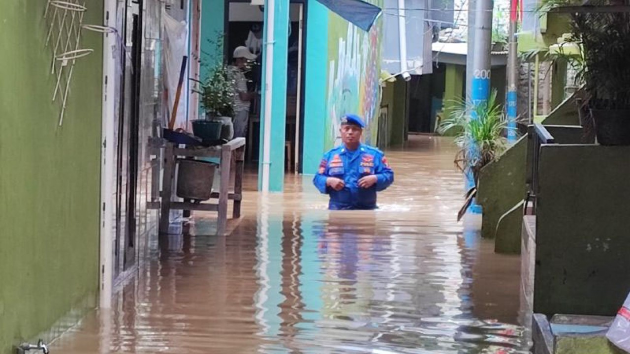 Seorang petugas dari Direktorat Kepolisian Perairan dan Udara (Polairud) Polda Metro Jaya tengah meninjau ketinggian air di permukiman warga yang terendam banjir di Kebon Pala, Kelurahan Kampung Melayu, Kecamatan Jatinegara, Jakarta Timur, Kamis (4/5/2023). ANTARA/Syaiful Hakim