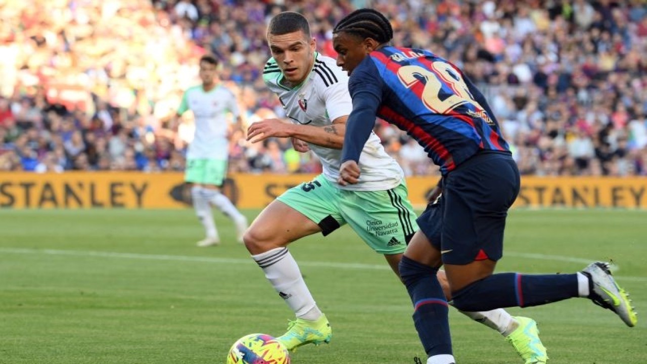 Arsip-Bek Osasuna Diego Moreno (kiri) berduel dengan bek Barcelona Alejandro Balde pada pertandingan Liga Spanyol yang dimainkan di Stadion Camp Nou, Barcelona, Selasa (2/5/2023). (ANTARA/AFP/LLUIS GENE)