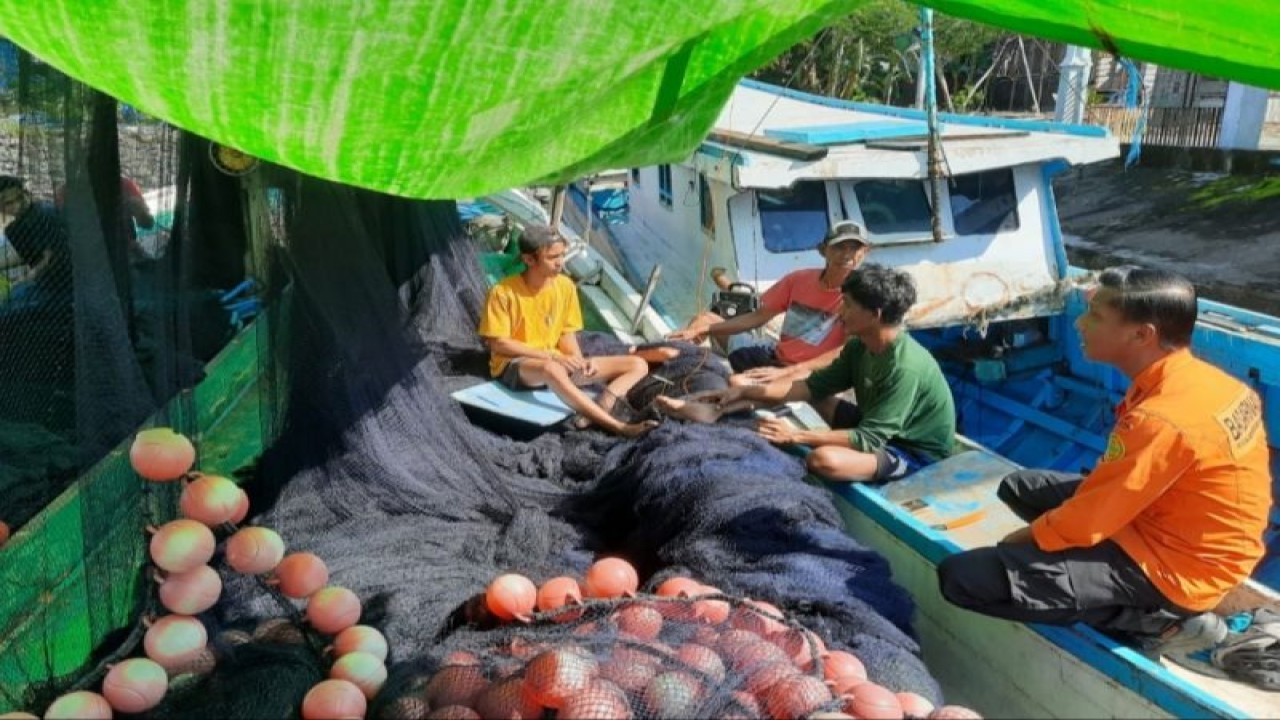 Personil Basarnas Sulsel berbincang dengan nelayan usai KMN Ilham Jaya ditemukan di Perairan sebelah barat Selayar, Sulawesi Selatan. ANTARA/HO/Dokumentasi Basarnas Sulsel.
