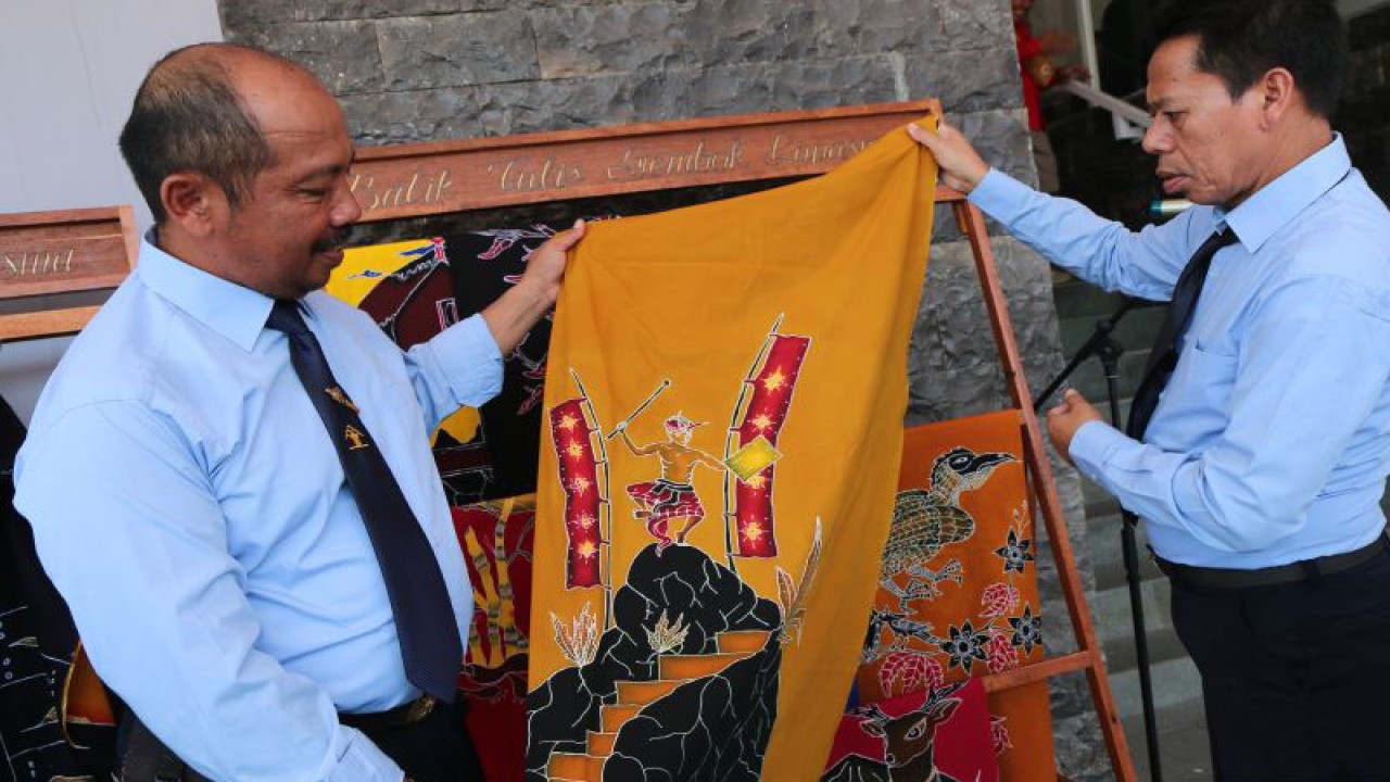 Kalapas Mataram Ketut Akbar Herry Acjhar (kiri) menunjukkan salah satu kain batik tulis dengan motif peresean karya warga binaan dalam perayaan Hari Bhakti Pemasyarakatan (HBP) ke-59 di Mataram, Selasa. (2/5/2023). ANTARA/Dhimas B.P.