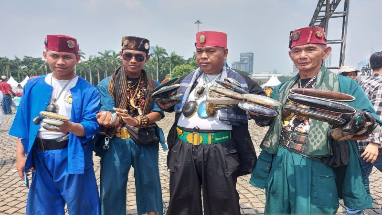 Kong Salim (kanan) dan ketiga rekannya memperlihatkan koleksi cincin batu pandan saat Lebaran Betawi di Lapangan Monas, Jakarta, Minggu (21/5/2023). ANTARA/Mentari Dwi Gayati