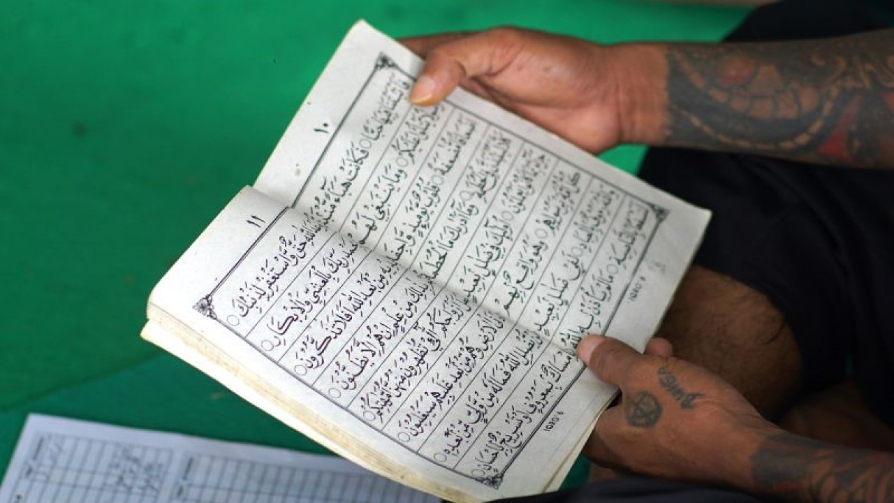 Seorang warga binaan pemasyarakatan belajar mengaji di pelataran masjid At Taubah dalam Lembaga Pemasyarakatan (Lapas) Kelas IIA, UPT Kanwil Kemenkumham Gorontalo di Kota Gorontalo, Gorontalo. ANTARA/Adiwinata Solihin