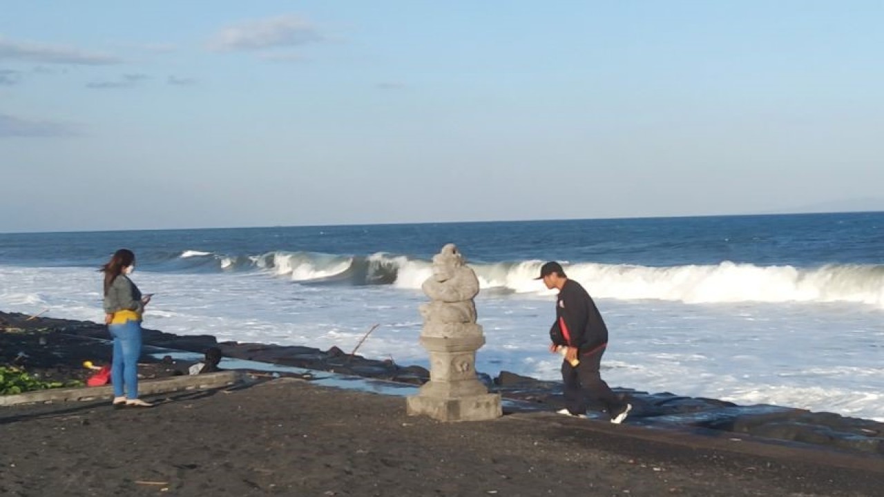 Pengunjung berjalan menikmati suasana deburan ombak tinggi di Pantai Purnama, Kabupaten Gianyar, Bali, Minggu (14/5/2023) ANTARA/Dewa Ketut Sudiarta Wiguna
