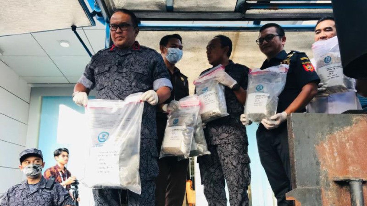 Kepala Badan Narkotika Nasional Provinsi Bali Brigjen Pol. Raden Nurhadi Yuwono (kiri) menunjukkan barang bukti berupa ganja kering sebelum dimusnahkan dalam mesin incenerator di halaman Kantor BNNP Bali, Denpasar, Selasa (16/5/2023). ANTARA/Rolandus Nampu