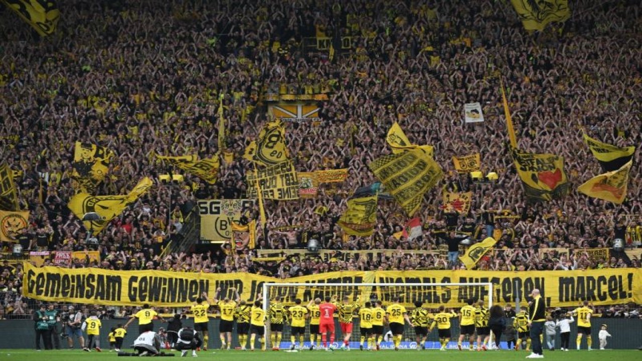 Para pemain Borussia Dortmund merayakan kemenangan atas Wolfsburg dengan skor 6-0 bersama suporter mereka pada pekan ke-31 Liga Jerman di Stadion Signal Iduna Park, Dortmund, Minggu (7/5/2023). (ANTARA/AFP/INA FASSBENDER)