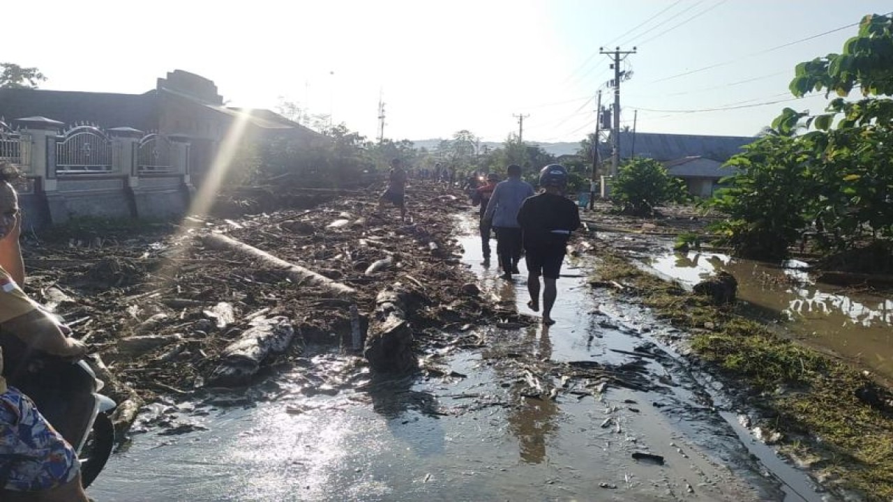 Tumpukan material kayu berserakan di jalan Desa Balinggi Jatih, Kabupaten Parigi Moutong, Sulawesi Tengah akibat dampak banjir yang melanda wilayah tersebut, Selasa (30/5/2023). ANTARA/HO-BPBD Parigi Moutong
