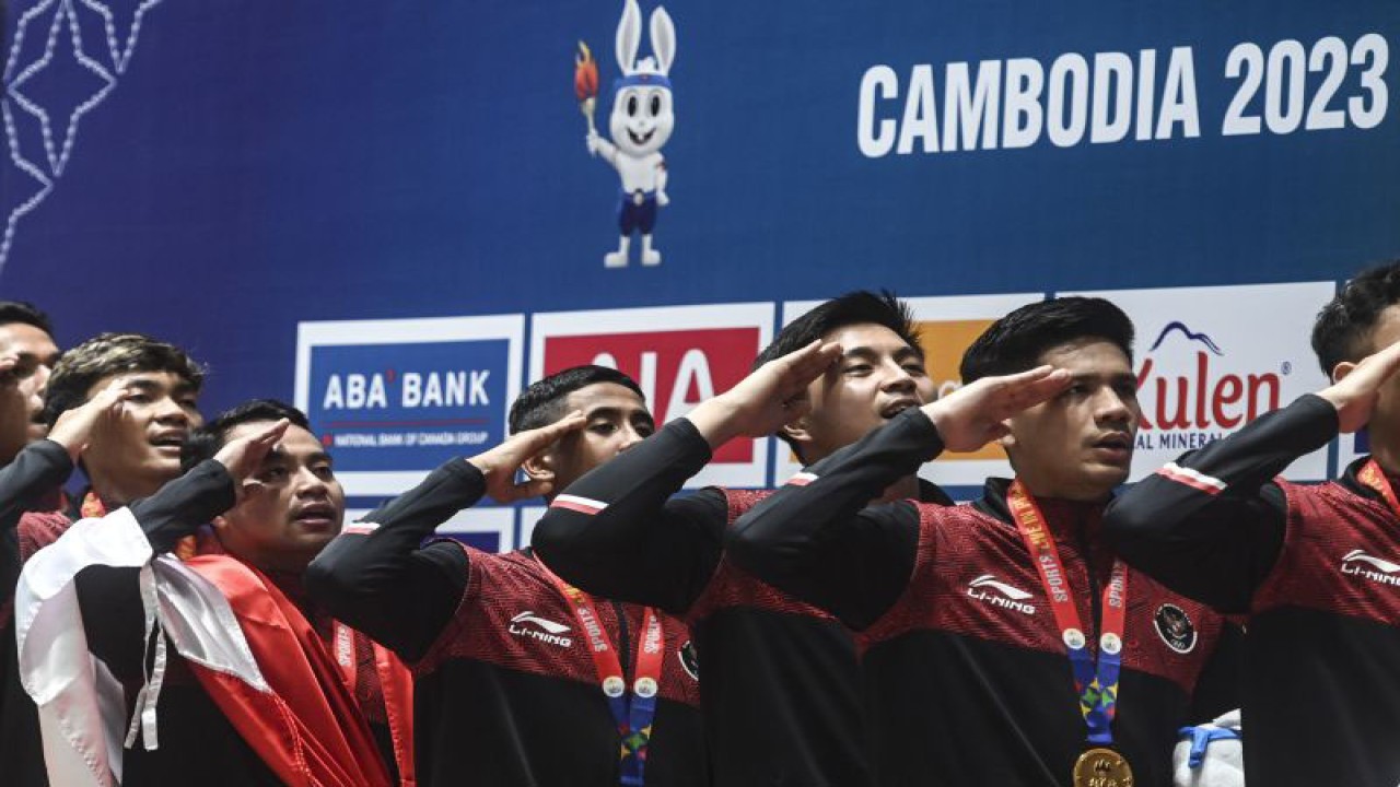 Pebulu tangkis ganda putra Indonesia melakukan penghormatan bendera saat upacara penyerahan medali usai pertandingan final bulu tangkis beregu putra SEA Games 2023 melawan Malaysia di Badminton Hall, Morodoc Techo National Stadium, Phnom Penh, Kamboja, Kamis (11/5/2023). ANTARA FOTO/Muhammad Adimaja/tom.