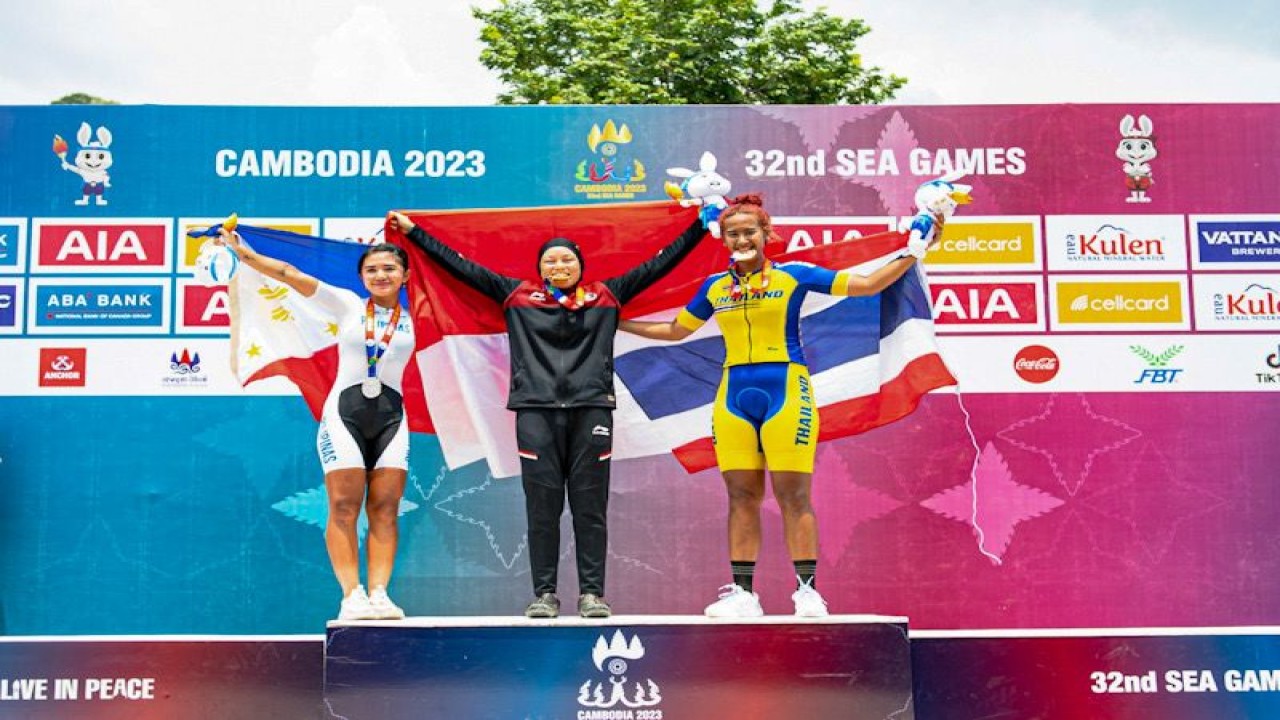 Dara Latifah (tengah) mengumandangkan lagu Indonesia Raya dan membuat Merah Putih berkibar pada SEA Games XXXII/2023 Kamboja setelah menjadi yang terbaik pada nomor XCE putri di Kulen Mountains, Siem Rep, Senin (8/5/2023) (ANTARA/HO-PB ISSI/Nick Hanoatubun)