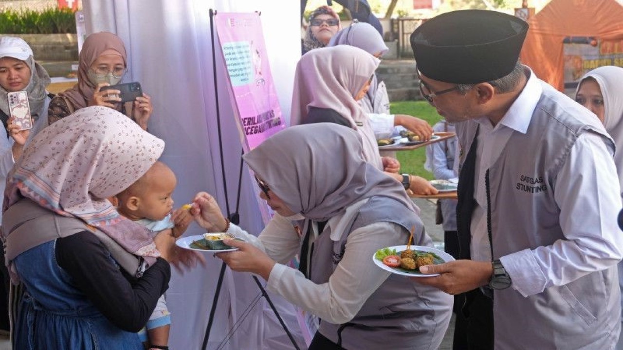 Petugas menyuapkan makanan bergizi kepada anak pada acara peluncuran program Bergerak Bersama Atasi Stunting di Alun-alun kota Temanggung, Jawa Tengah, Jumat (12/5/2023). (ANTARA FOTO/ANIS EFIZUDIN/foc)
