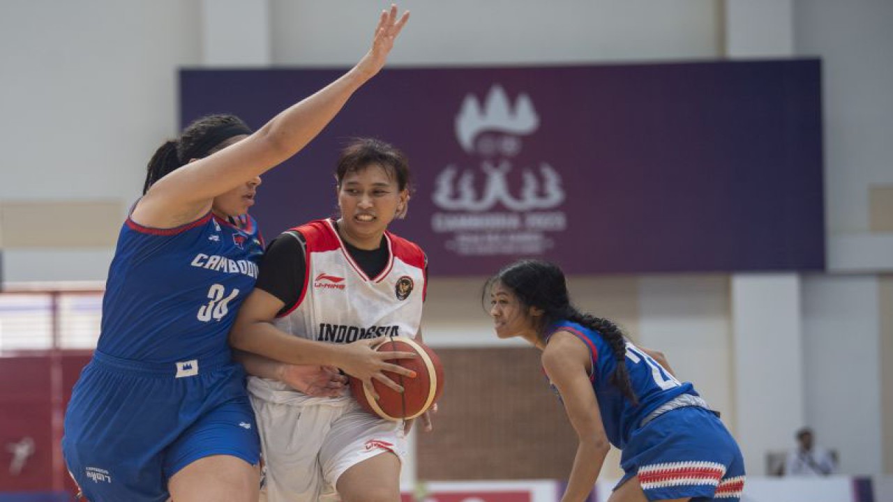 Pebasket putri Indonesia Yuni Anggraeni (tengah) melakukan dribble dibayangi pebasket putri Kamboja Jasmine Davina (kanan) dan Mariah Cooks (kiri) saat pertandingan Basket 5X5 SEA Games 2023 di Elephant Hall 2, Morodok Techo Indoor Sports Center, Phnom Penh, Kamboja, Sabtu (13/5/2023). ANTARA FOTO/M Agung Rajasa/aww.