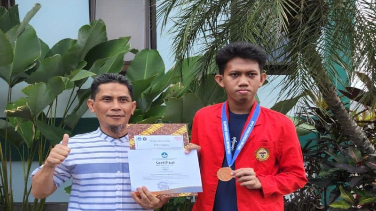Ferdi, salah satu mahasiswa Unhas menunjukkan medali perak dan piagam penghargaan yang diraih pada ajang Olimliade Matematika 2023 di Rusia.ANTARA/HO