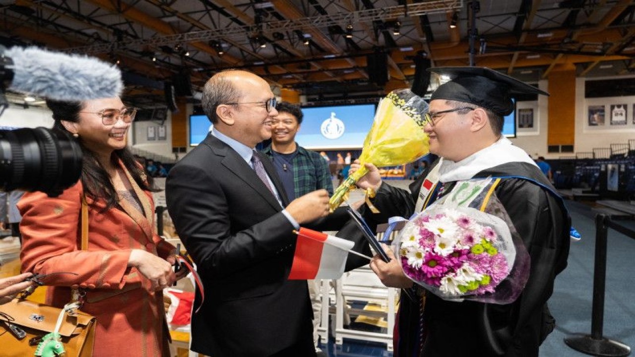 Duta Besar RI untuk Amerika Serikat (AS) Rosan Perkasa Roeslani (dua dari kiri) memberikan selamat kepada mahasiswa tunarungu asal Indonesia, Phieter Angdika (kanan), yang telah menyelesaikan Program Studi S2 untuk Pendidikan Bahasa Isyarat (Master of Sign Language Education/MASLED) di Universitas Gallaudet, Washington DC, Amerika Serikat. ANTARA/HO-Dubes AS