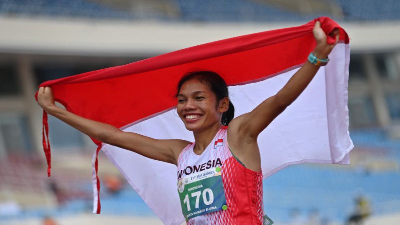 Pelari Indonesia Odekta Elvina Naibaho membentangkan bendera Merah Putih usai memenangi nomor lari maraton putri SEA Games Vietnam 2021 di Stadion Nasional My Dinh, Hanoi, Vietnam, Kamis (19/5/2022). ANTARA FOTO/Aditya Pradana Putra/foc. (ANTARA FOTO/ADITYA PRADANA PUTRA)