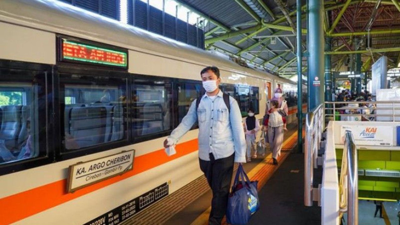 Penumpang kereta api melintas di samping kereta Argo Cheribon relasi Cirebon-Gambir di Stasiun Gambir Jakarta. ANTARA/HO-PT KAI/aa.
