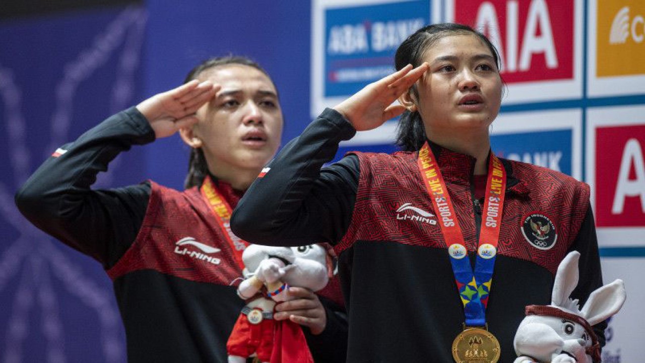 Pebulu tangkis ganda putri Indonesia Amalia Cahaya Pratiwi (kanan) dan Febriana Dwipuji Kusuma (kiri) memberi hormat saat pengibaran bendera Merah Putih pada upacara penganugerahan medali bulu tangkis ganda putri SEA Games 2023 di Badminton Hall, Morodoc Techo National Stadium, Phnom Penh, Kamboja, Selasa (16/5/2023). ANTARA FOTO/M Agung Rajasa/rwa.