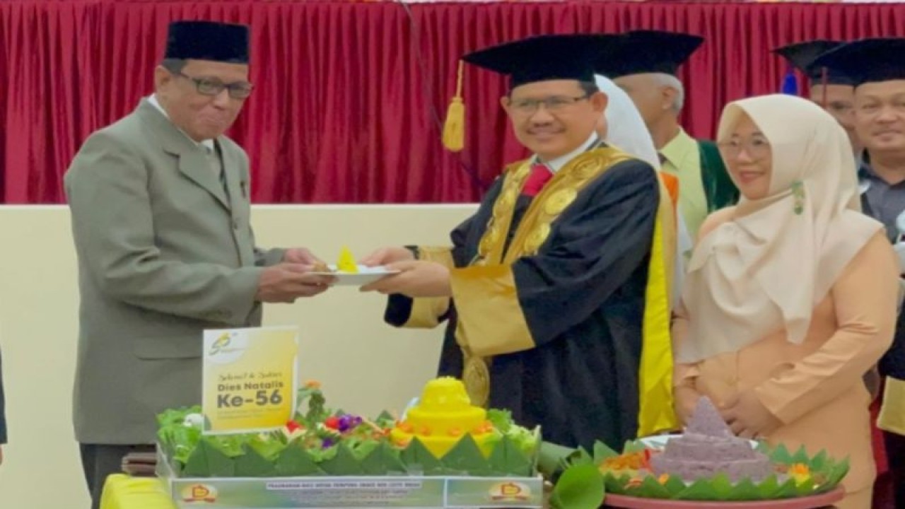 Rektor UIN Palu Profesor Sagaf Pettalongi (kiri) menyerahkan tumpeng kepada Asisten Pemerintahan dan Kesra Setda Pemprov Sulteng Fahruddin Yambas, di Palu, Rabu (17/5/2023). (ANTARA/HO-Biro Administrasi Pimpinan Setda Pemprov Sulteng)
