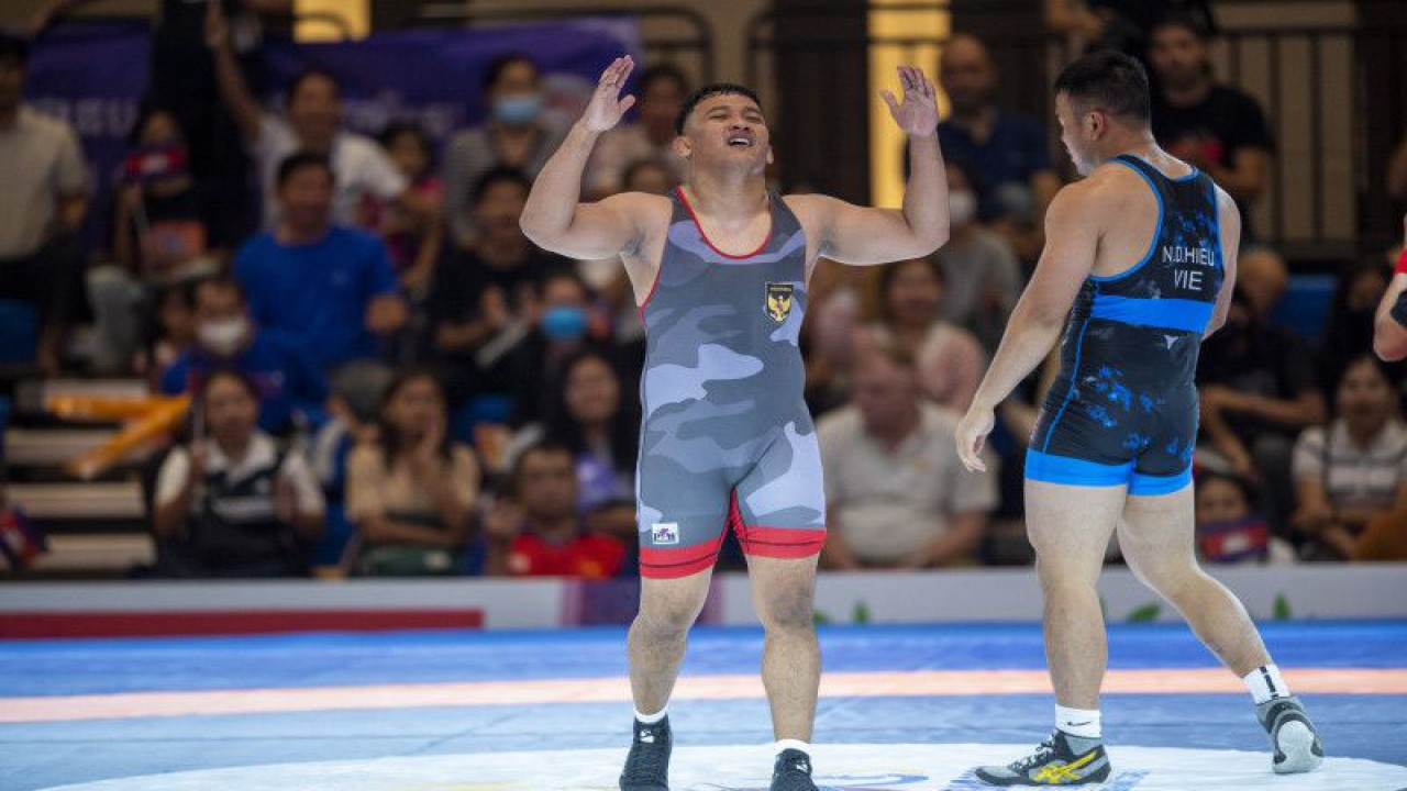 Pegulat putra Indonesia Lulut Gilang Saputra (kiri) meluapkan kegembiraan seusai mengalahkan pegulat Vietnam Dinh Hieu Nghiem (kanan) saat pertandingan gulat gaya Yunani Romawi (Greco Roman) 87 kilogram putra SEA Games 2023 di Chroy Changvar International Convention & Exhibition Center, Phnom Penh, Kamboja, Minggu (14/5/2023). Lulut berhasil meraih medali emas usai mengalahkan pegulat Vietnam dengan skor 7-5, sehingga menduduki peringkat pertama dengan total 25 poin yang diikuti pegulat Vietnam Dinh Hieu Nghiem dengan 20 poin dan perunggu pegulat Kamboja Chheoung Veasna 15 poin. ANTARA FOTO/M Agung Rajasa/nym.