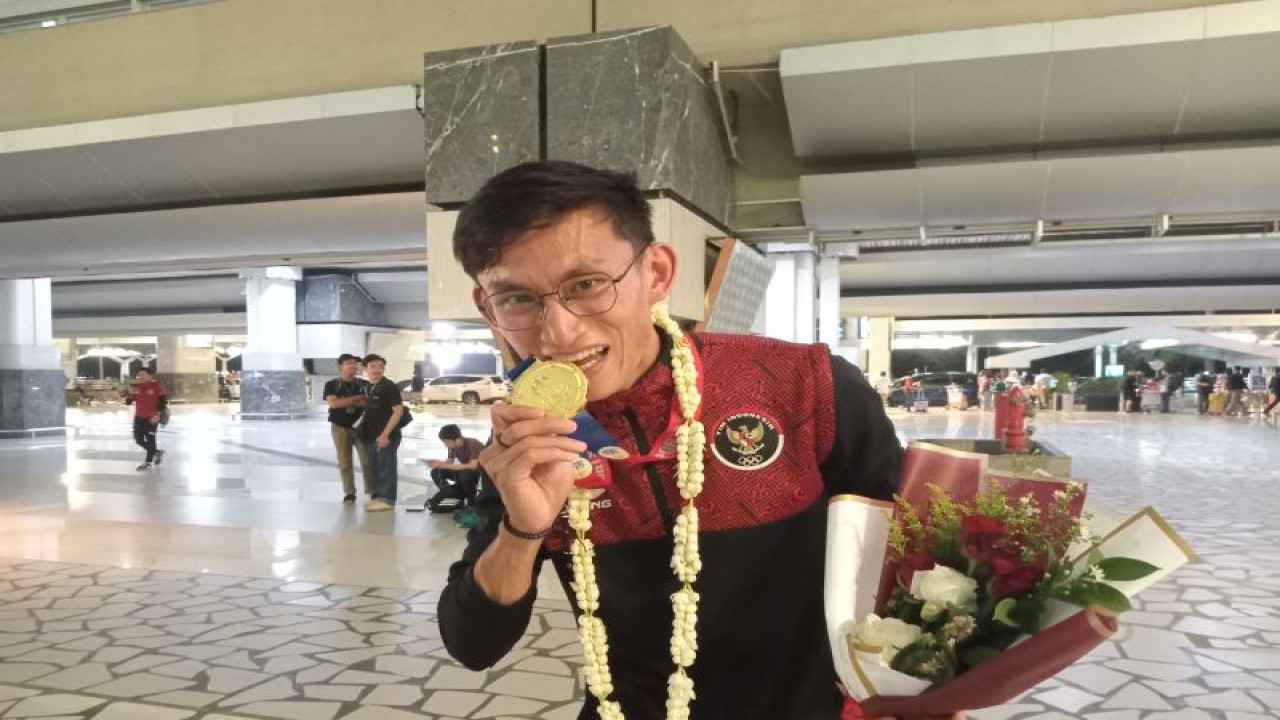 Pemenang medali emas jalan cepat 20 kilometer putra SEA Games 2023 Hendro Yap berpose setelah acara penjemputan atlet di Bandara Soekarno-Hatta, Tangerang, Rabu (10/5/2023). (ANTARA/RAUF ADIPATI)