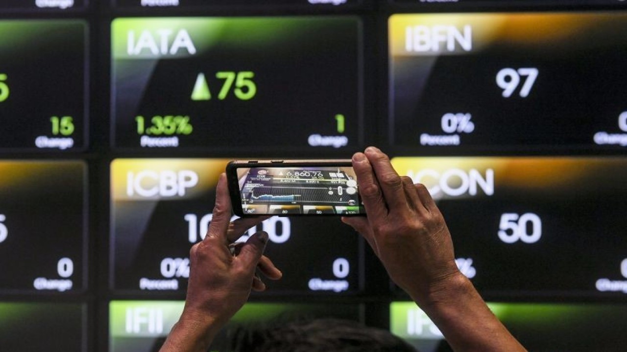 Pekerja memotret layar yang menampilkan pergerakan Indeks Harga Saham Gabungan (IHSG) di Bursa Efek Indonesia, Jakarta, Rabu (26/4/2023). ANTARA FOTO/Hafidz Mubarak A/foc.