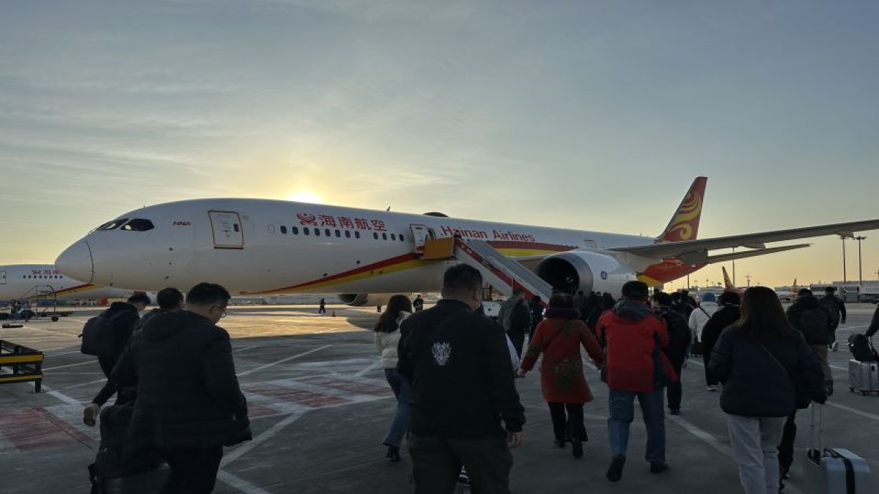 Para penumpang bersiap menaiki tangga pesawat di Bandar Udara Internasional Ibu Kota Beijing (BCIA) China pada pertengahan Februari 2023. (ANTARA/M. Irfan Ilmie)