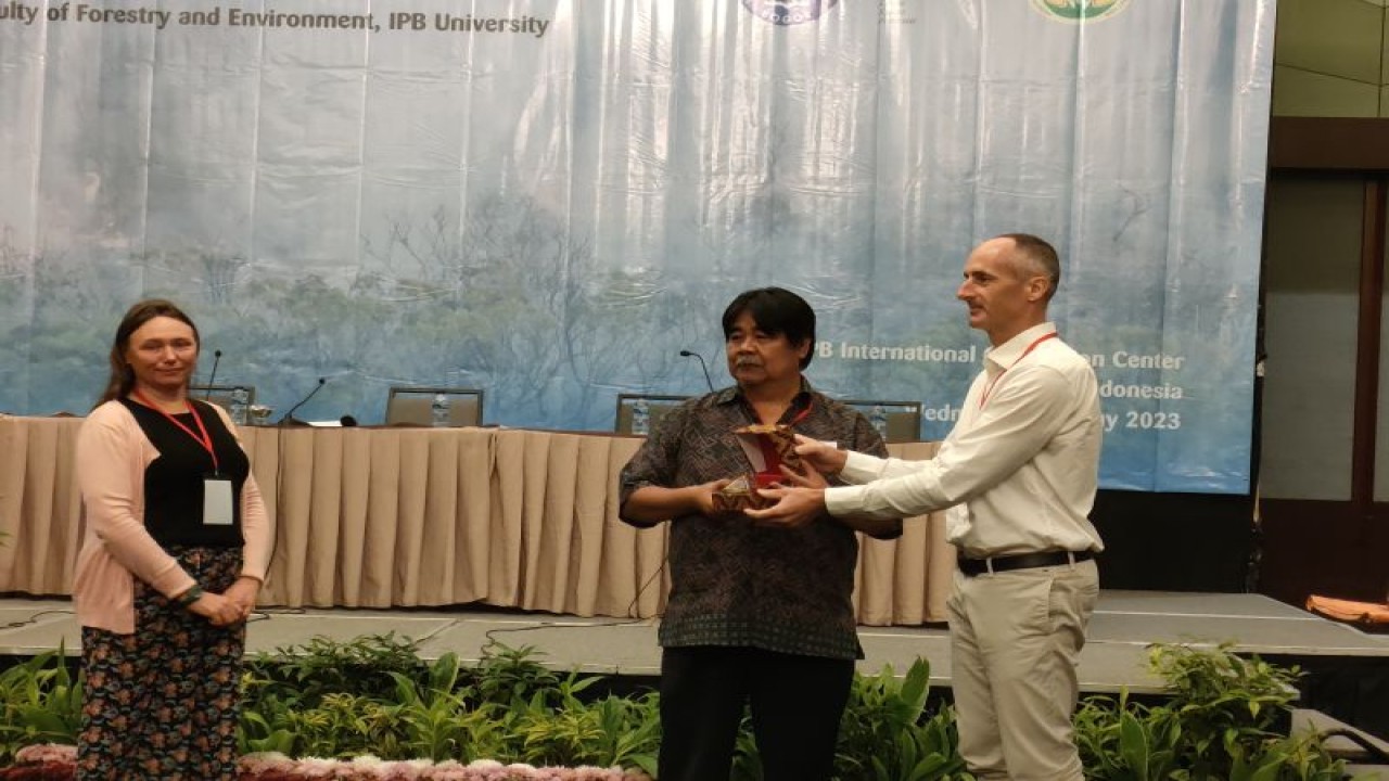 Guru Besar Fakultas Kehutanan dan Lingkungan (Fahutan) IPB University , Prof Bambang Hero Saharjo saat menerima cindera mata dari perwakilan organisasi yang konsentrasi terhadap karhutla Prancis di sela seminar internasional kebakaran hutan dan lahan di IICC Botani Square, Rabu (10/5/2023). (ANTARA/Linna Susanti)