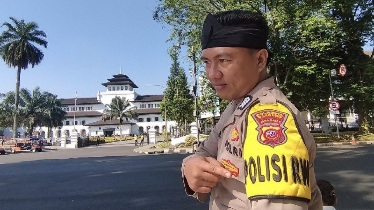 Seorang polisi menunjukkan penanda Polisi RW usai mengikuti apel peluncuran Polisi RW di halaman Gedung Sate, Kota Bandung, Jawa Barat, Senin (15/5/2023). ANTARA/HO-BG