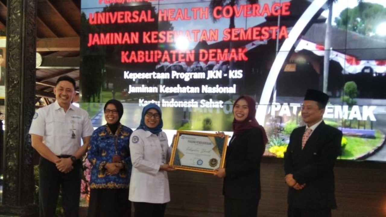 Deputi Direksi Wilayah VI BPJS Kesehatan Dwi Martiningsih menyerahkan penghargaan UHC kepada Bupati Demak Eisti'anah dengan disaksikan Asisten Pemerintahan dan Kesejahteraan Rakyat Setda Jateng Ema Rachmawati di Pendopo Kabupaten Demak, Senin (22/5/2023). (ANTARA/Akhmad Nazaruddin Lathif)