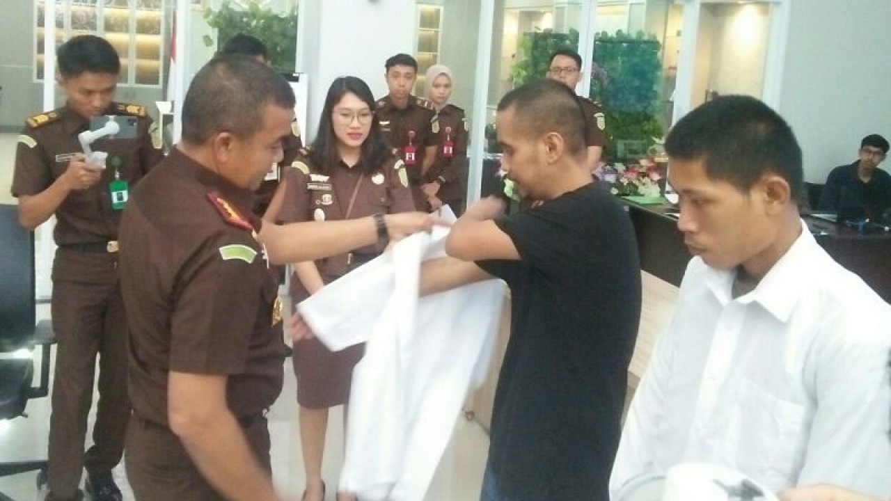Kajari Samarinda Firmansyah Subhan (kiri) memakaikan baju biasa kepada dua orang mantan tersangka setelah dilakukan keadilan restoratif, Senin (22/5/2023). ANTARA/ M Ghofar