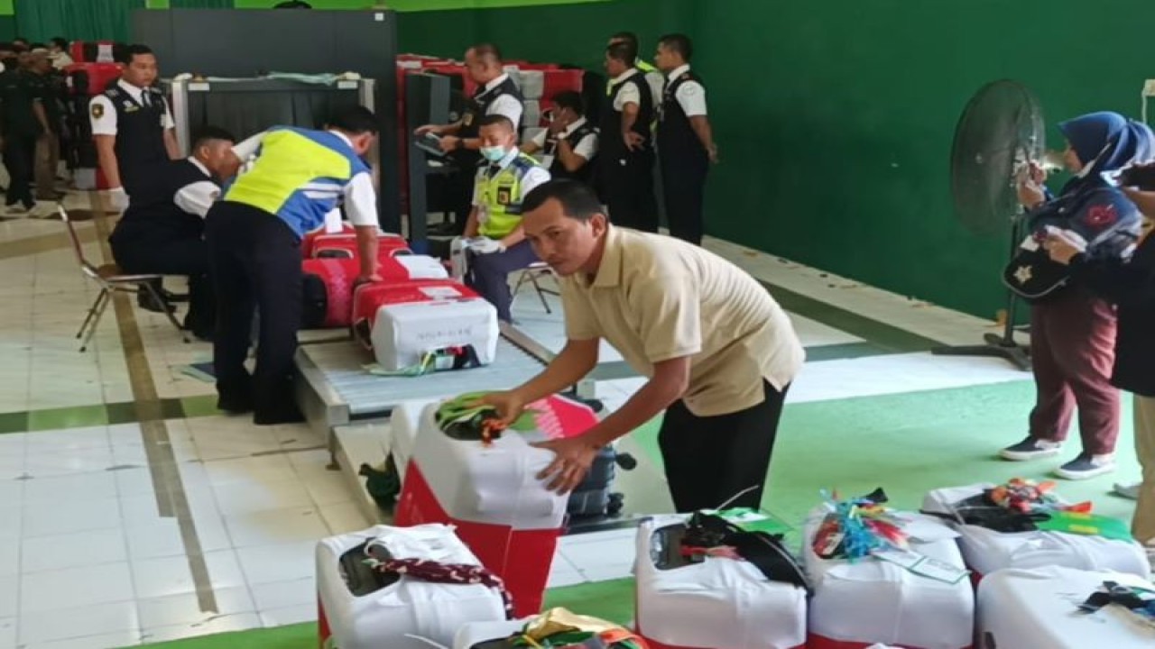 Petugas menata koper milik jamaah calon haji kloter 1 setelah melalui pemeriksaan alat sinar x di Asrama Haji Embarkasi Surabaya, Selasa (23/5/2023). (ANTARA/Hanif Nashrullah)